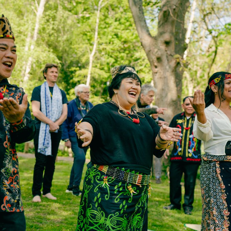 Indigenous activists smiling and dancing among trees