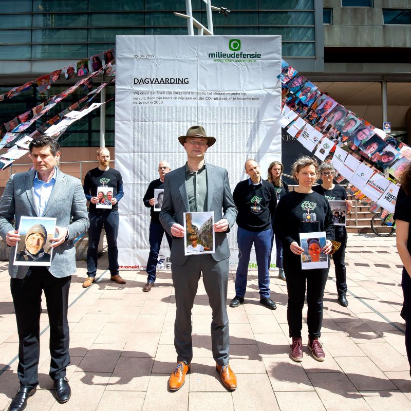 Dutch campaigners stand in front of photos of the 17,000 claimants who took Shell to court and won.