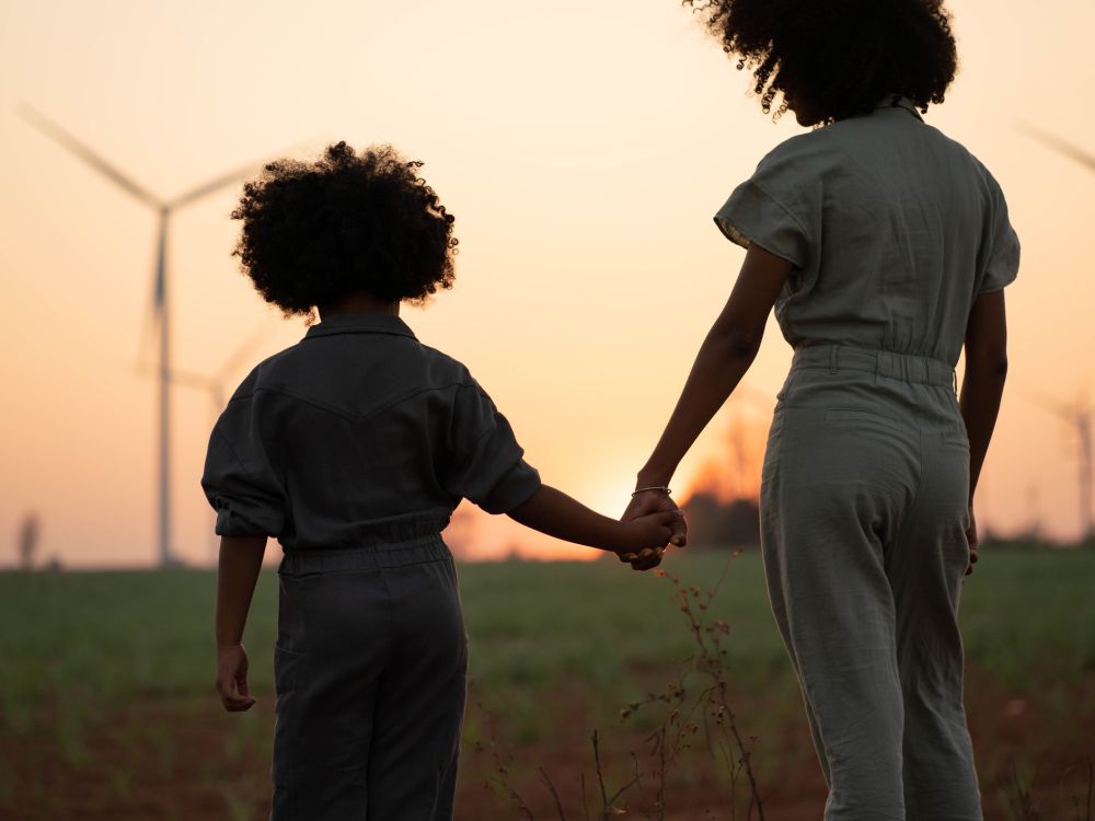 Parents take their children to visit and admire renewable energy windmills