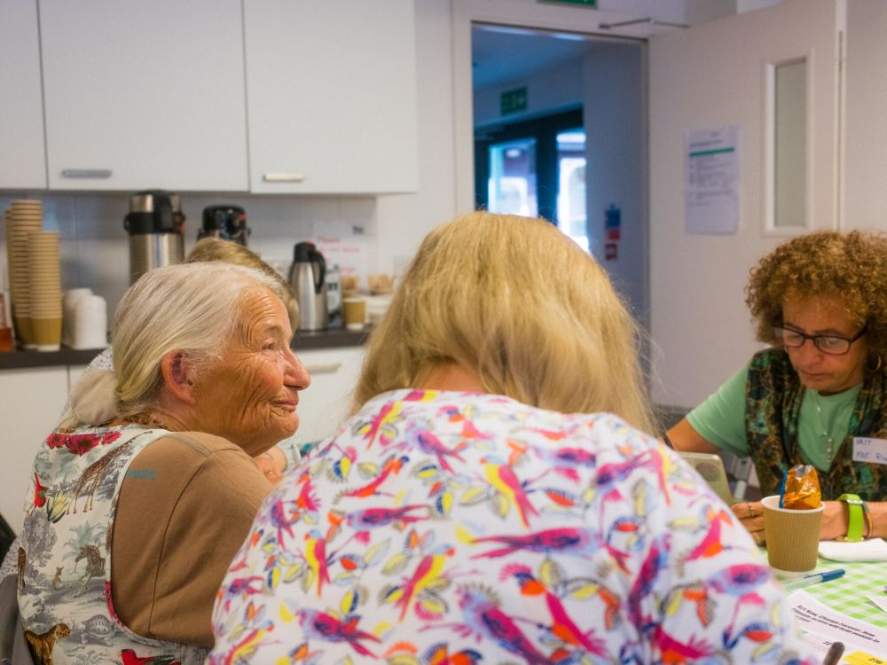 Four people sitting round a table in a kitchen.