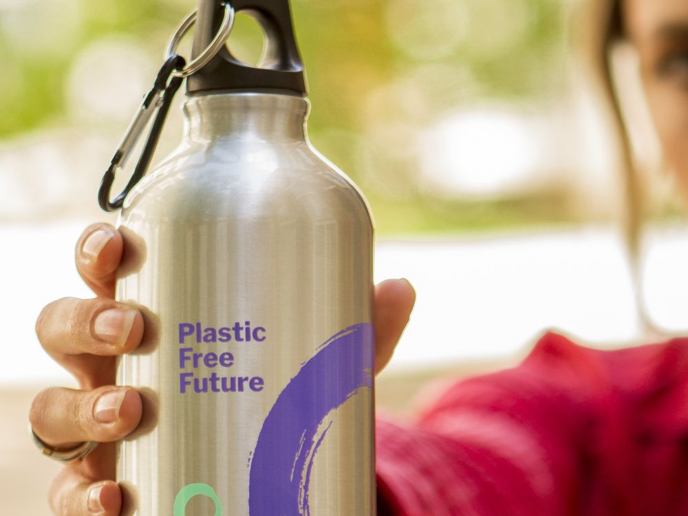 Close-up of woman holding Friends of the Earth Plastic-Free aluminium water bottle