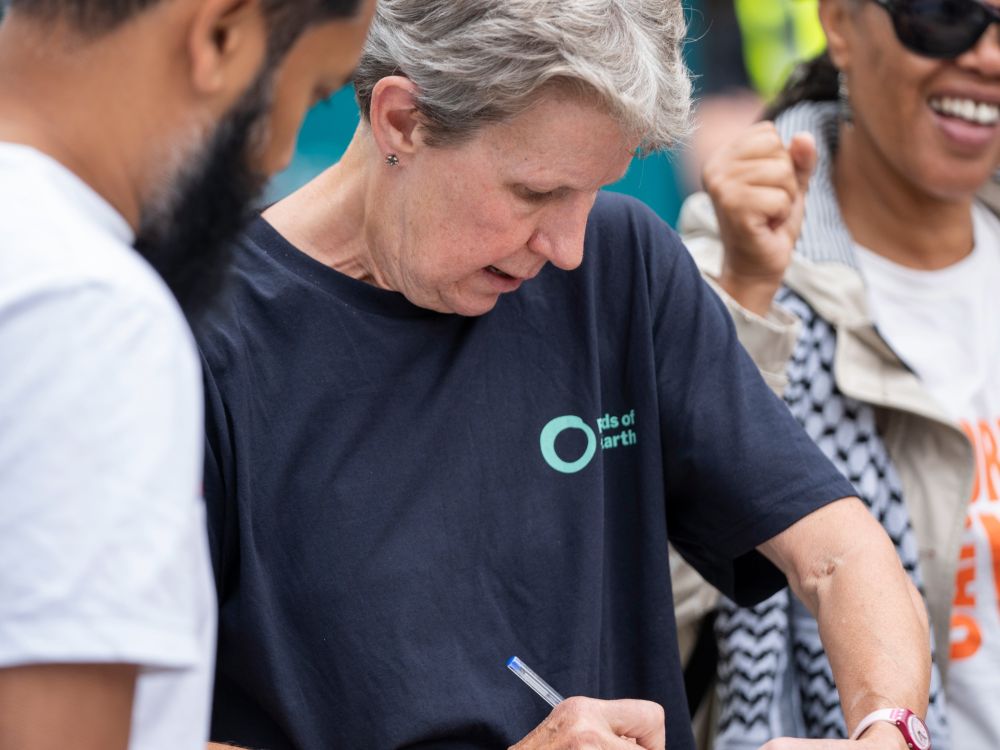 A Friends of the Earth local action group member taking details down on a clipboard